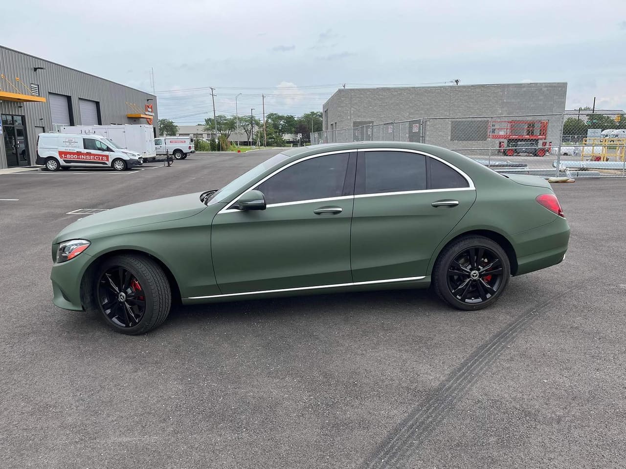Mercedes-Benz C-Class sedan in a full matte army green colour-change wrap, side profile, on black wheels with red calipers